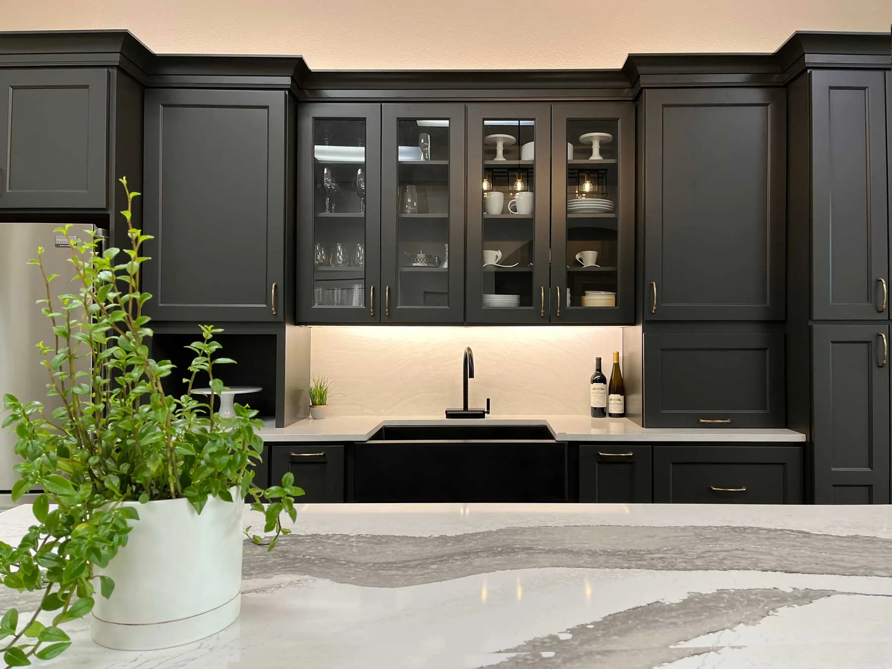 Dark custom cabinetry with quartz countertops from a Crafted Spaces kitchen remodel